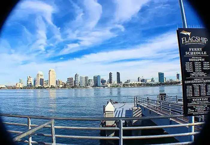 Coronado Ferry Landing con tiendas frente al mar y vistas al skyline de San Diego.